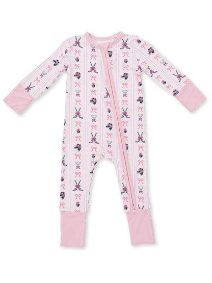 Pink baby onesie featuring patterns of bows, scissors, and ballet shoes. Full zip front and long sleeves.