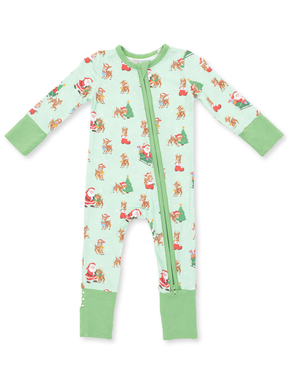 Light green kids' pajama onesie with festive prints of Santa, reindeer, and Christmas trees.