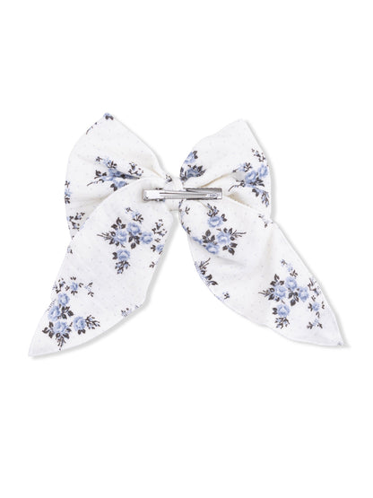 White hair bow with blue floral pattern and a silver clip at the center.