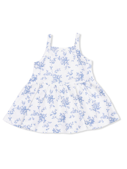 White dress with blue floral pattern and spaghetti straps, featuring a flared skirt. Perfect for summer wear.