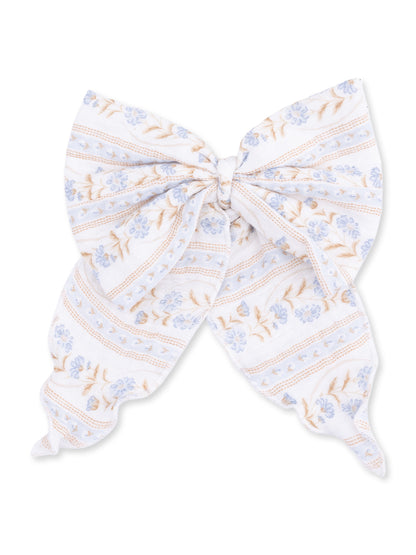 White fabric bow with blue floral patterns and stripes, perfect for hair accessories or decorations.