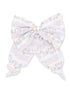 White fabric bow with blue floral patterns and stripes, perfect for hair accessories or decorations.