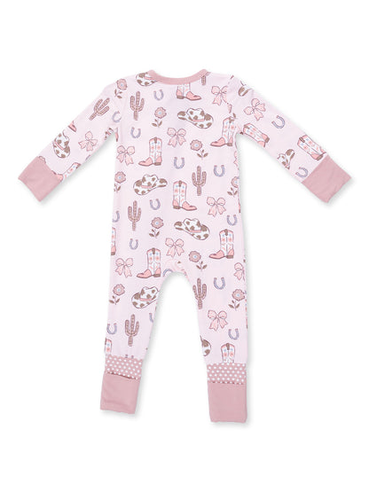 Pink baby onesie with cowboy-themed patterns like boots, cacti, and bows, featuring long sleeves and polka dot cuffs.