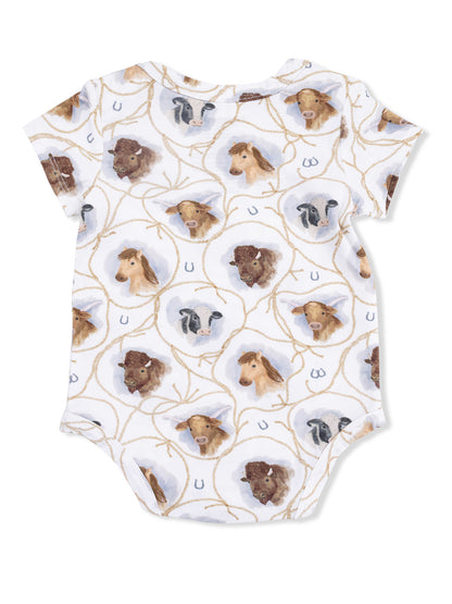 White baby onesie with watercolor animal faces, including horses, cows, and goats, in a playful pattern.