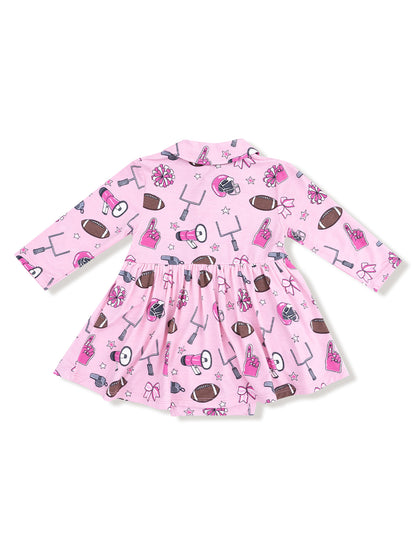 Pink dress with football and cheerleading patterns, featuring long sleeves and a flared skirt.