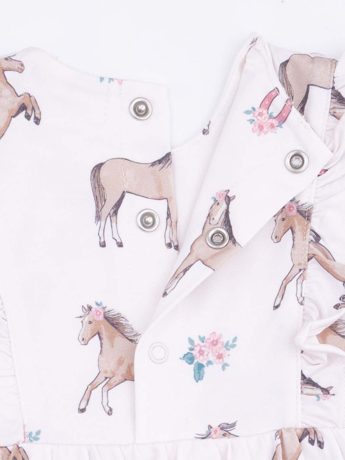 Pink dress with horse prints and floral accents, featuring snap buttons and a ruffled hem.