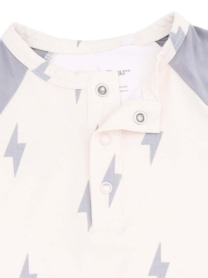 Light-colored shirt with gray lightning bolt patterns and snap buttons at the collar.