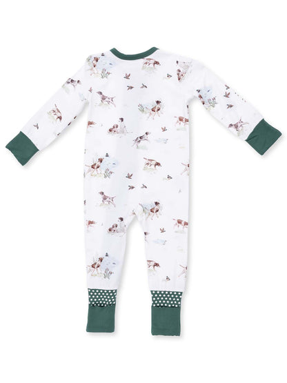 Back view of a baby onesie featuring a playful dog and bird pattern with green trim and polka dot accents.
