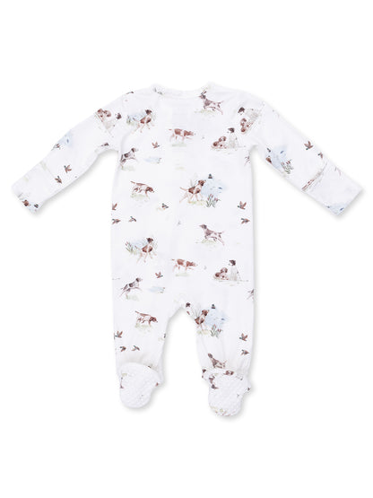 White baby onesie with playful dog and nature print, featuring long sleeves and footed design.