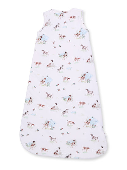 Children's sleep sack featuring a pastel print of playful dogs and birds on a white background.