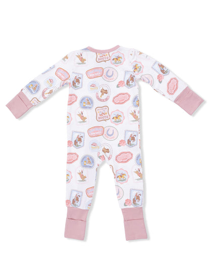 Baby pajamas with cowboy-themed prints and pink cuffs, viewed from the back.
