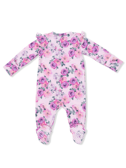 Floral baby onesie with ruffled shoulders and decorative polka dot grip on the feet, viewed from the back.