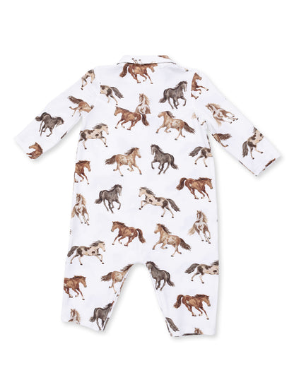White children's onesie featuring a playful print of galloping horses in various colors.