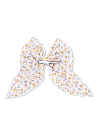 Floral hair bow with yellow flowers on a white background, secured with a silver clip.