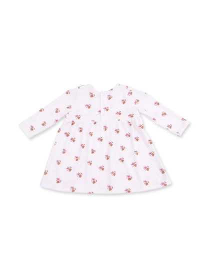 White dress with long sleeves, featuring a playful cupcake pattern throughout. 