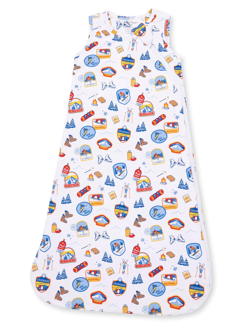 White sleep sack with colorful travel-themed patches and icons for winter activities. Ideal for cozy sleep.