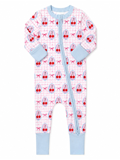 Baby onesie with cherry pattern on pink checkered background and blue cuffs, featuring a front zipper.