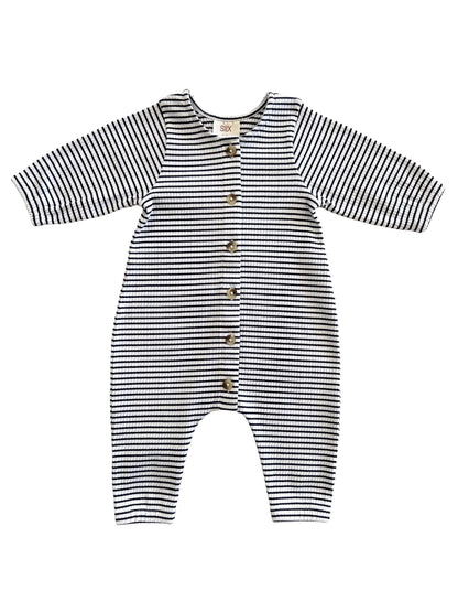 Striped baby jumpsuit with long sleeves and button closure, featuring black and white horizontal stripes.