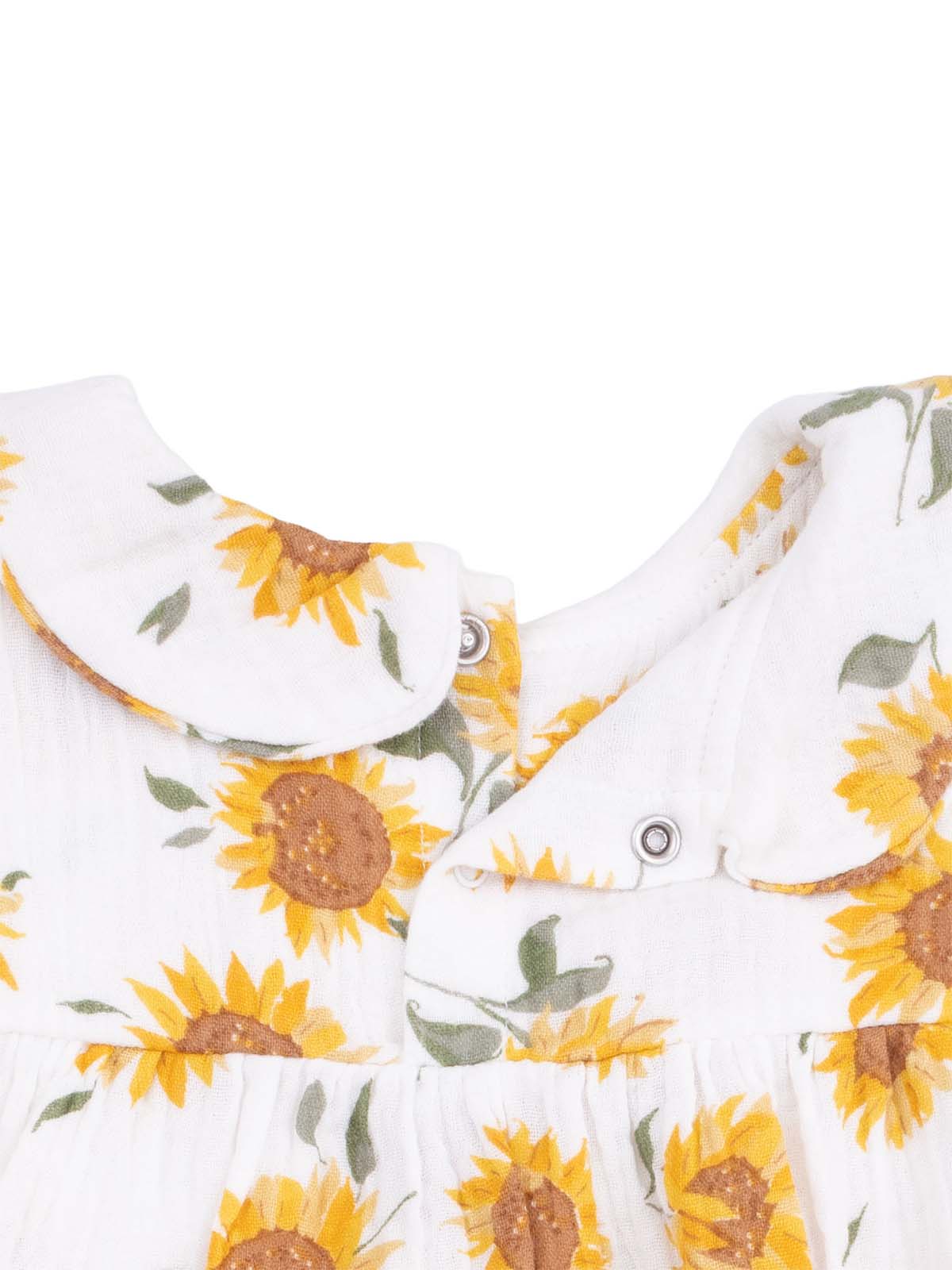 White fabric with sunflower print and a collared neckline, featuring snap buttons. Perfect for warm weather.