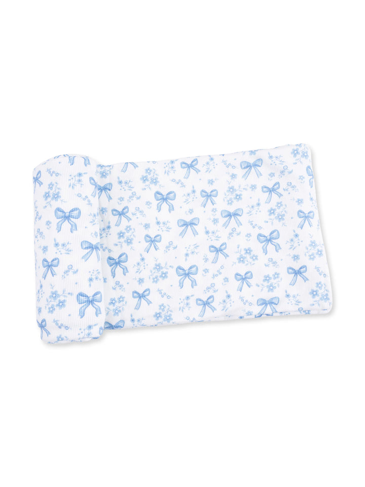 Blue and white patterned fabric featuring bows and flowers laid flat.