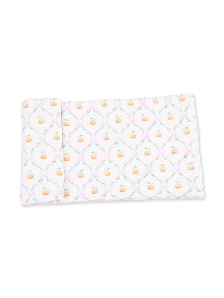 Patterned fabric featuring small pumpkins and floral designs on a white background.