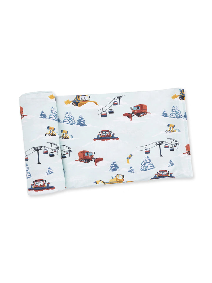 Colorful fabric featuring winter vehicles, trees, and ski lifts against a snowy background.