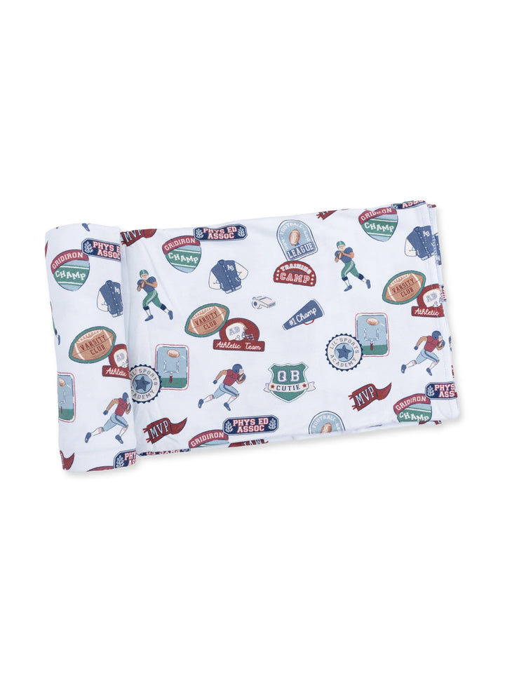 Patterned fabric with sports-themed badges and illustrations, featuring football and baseball motifs in various colors.