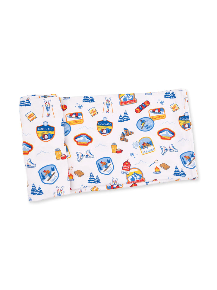 Colorful fabric featuring outdoor-themed designs, including mountains, skiing, and state patches.