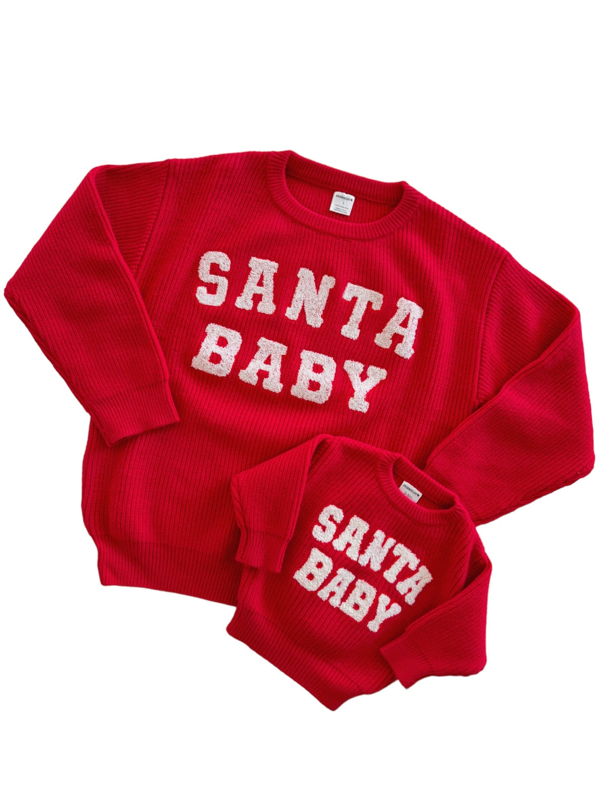 Red "Santa Baby" sweaters for adults and children, featuring textured white lettering. Perfect for festive family photos.