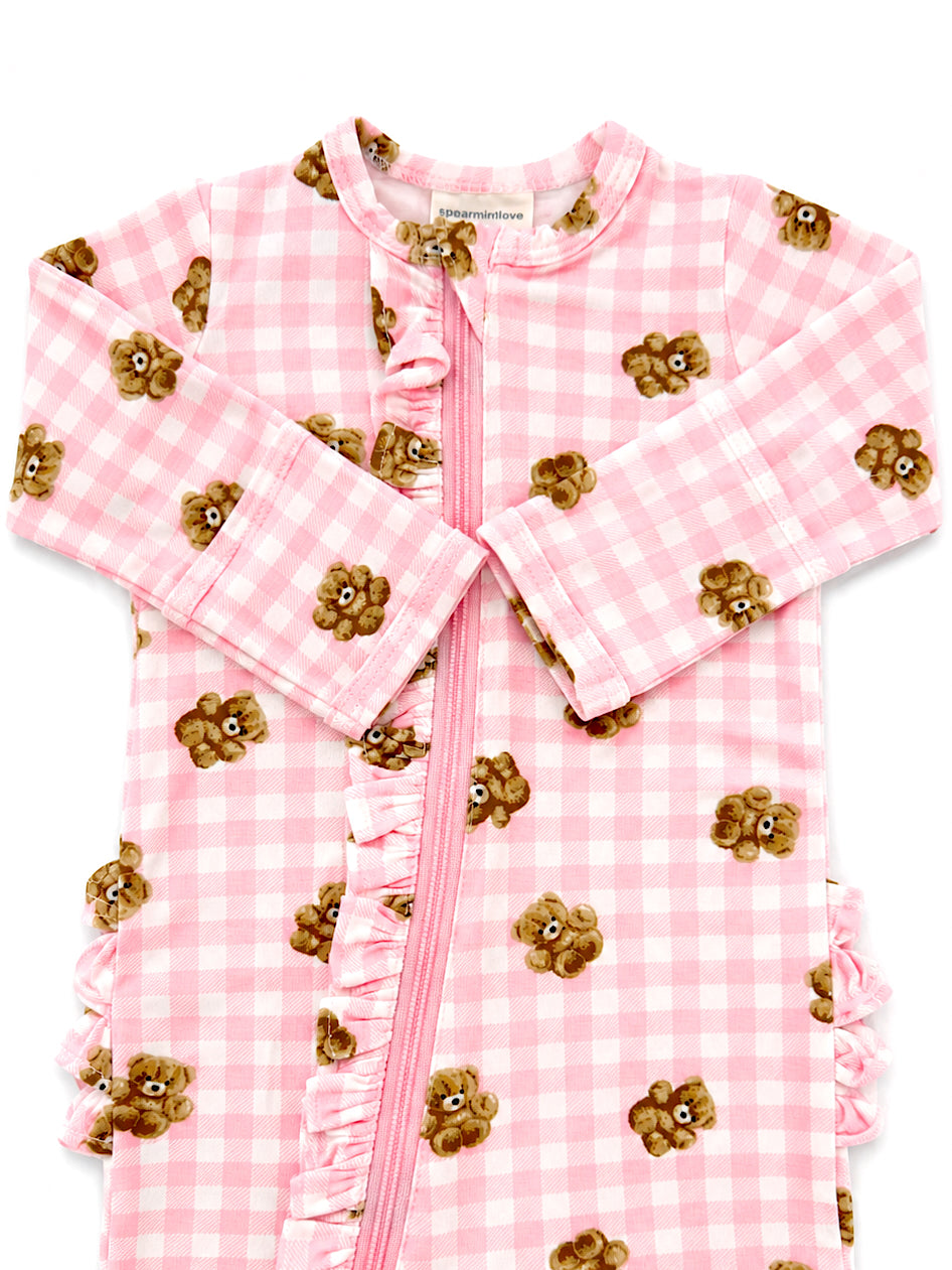 Pink checkered baby zip-up onesie with bear print and ruffle details. Ideal for cozy, playful moments.