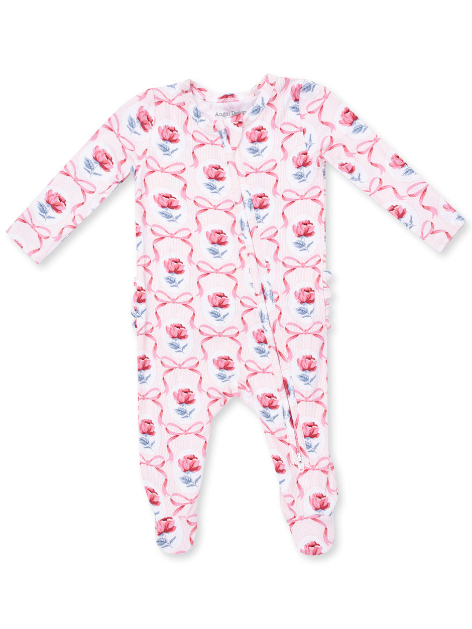 Pink floral infant onesie with long sleeves and front snap closure, featuring roses and ribbons in a playful pattern.