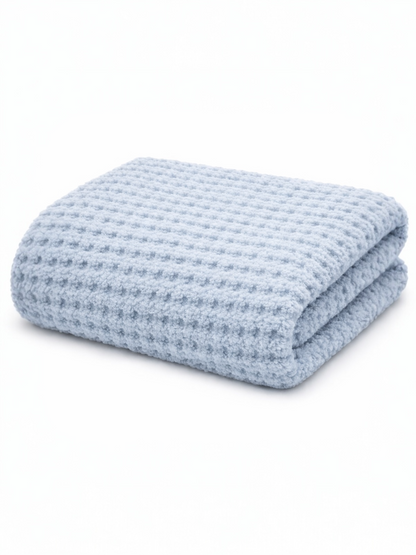 Light blue textured blanket folded neatly on a white background. Ideal for warmth and comfort.
