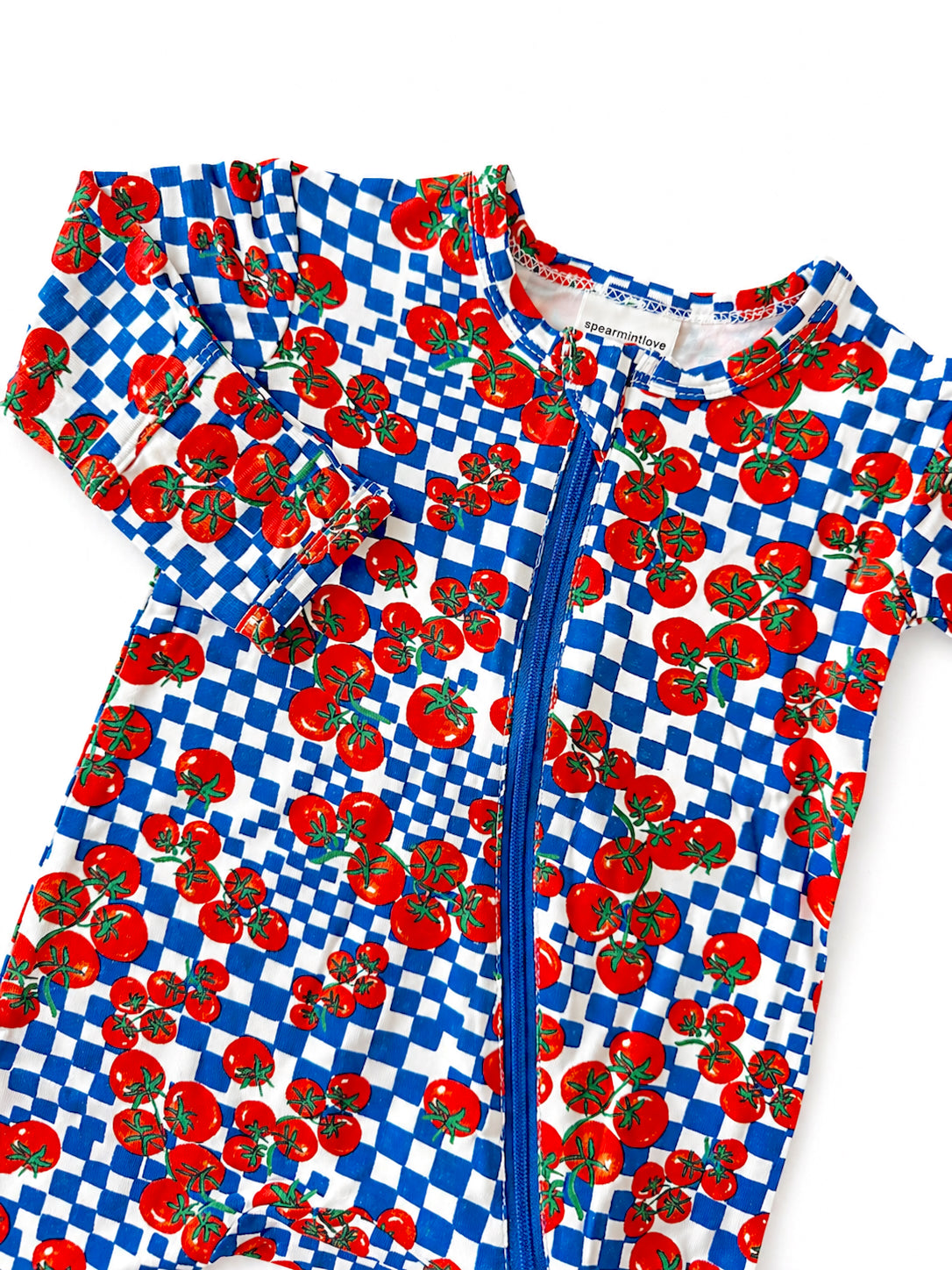 Colorful toddler swim onesie with red tomatoes and blue checkered pattern, featuring a front zipper.