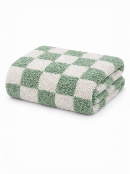 Folding green and white checkered towel stacked neatly on a white background.