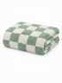 Folding green and white checkered towel stacked neatly on a white background.