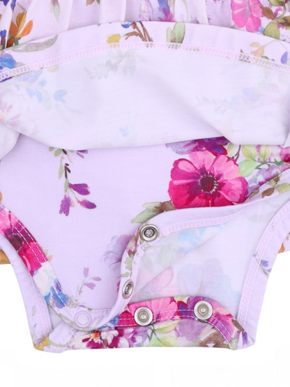 Floral-patterned baby onesie with snap closure at the bottom, featuring shades of purple, pink, and green.