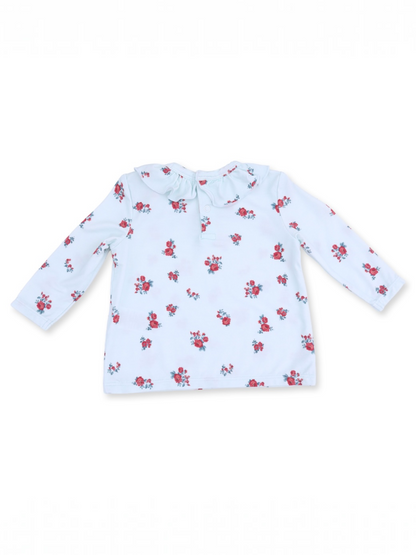 Long-sleeve children's shirt in light blue with a floral pattern and ruffled collar detail.