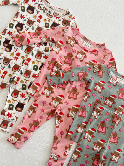 Four pairs of festive children's pajamas featuring reindeer and gingerbread designs in playful colors.