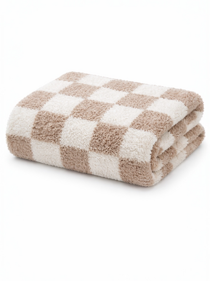 Folded beige and white checkered towel on a white background. Soft texture suitable for bath use.