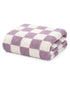 Folded checkered towel in soft purple and white fabric, ideal for bathrooms or spa settings.