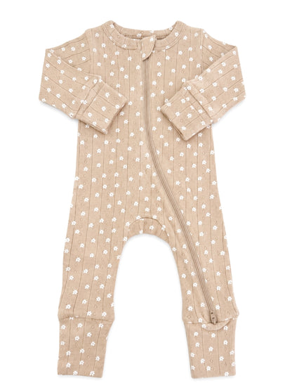 Baby onesie in light beige with white floral patterns and a front zipper. Ideal for comfortable sleepwear.