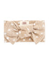 Beige headband with white floral patterns and a large bow, labeled "SIIX COLLECTIVE."