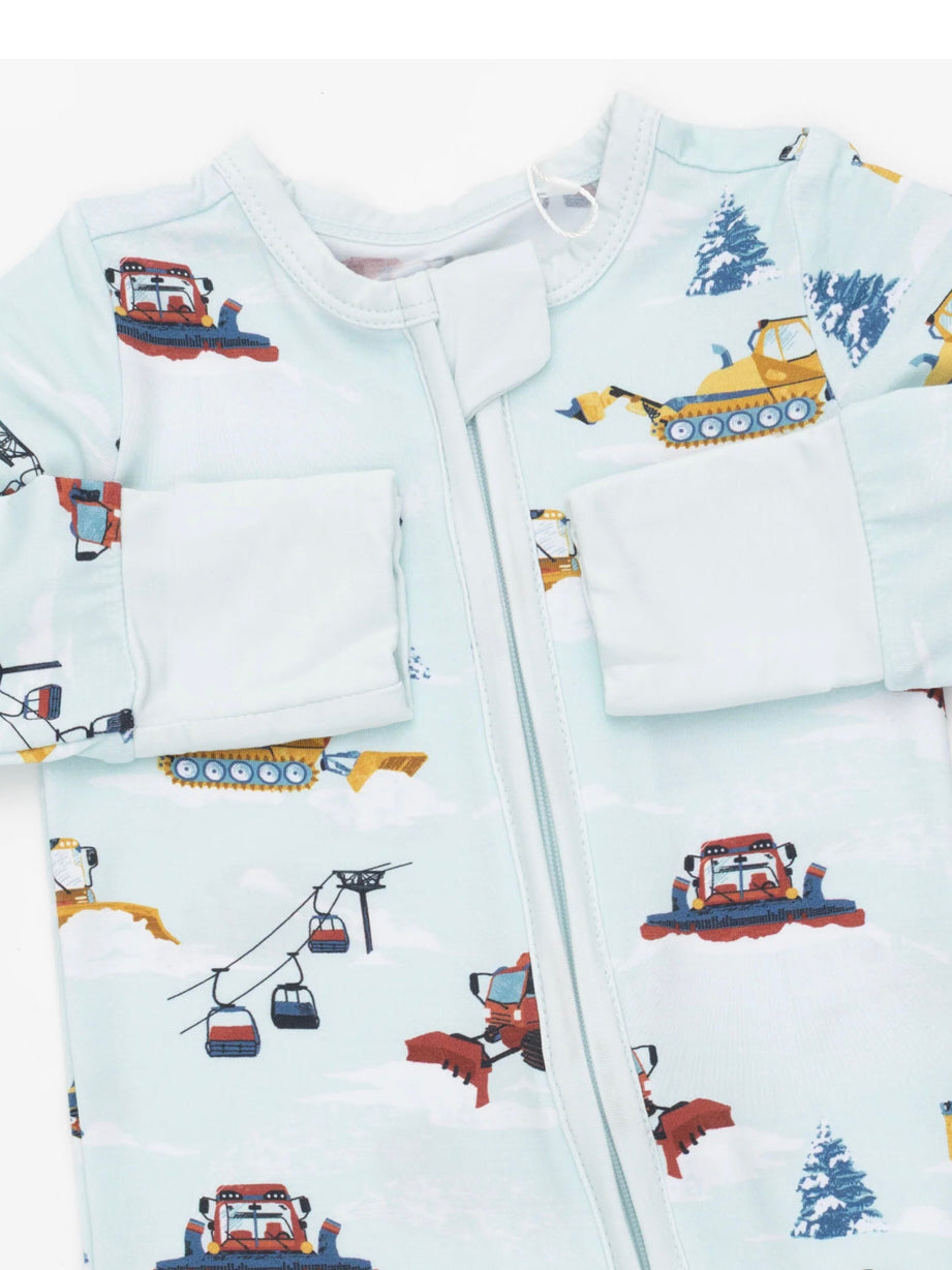 Blue zip-up pajama featuring fun patterns of snowplows, excavators, and ski lifts surrounded by clouds and trees.