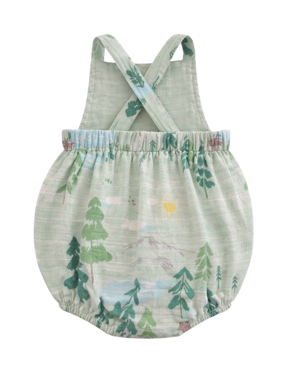Green romper with crossback straps featuring mountain and tree patterns. Ideal for playful, outdoor adventures.