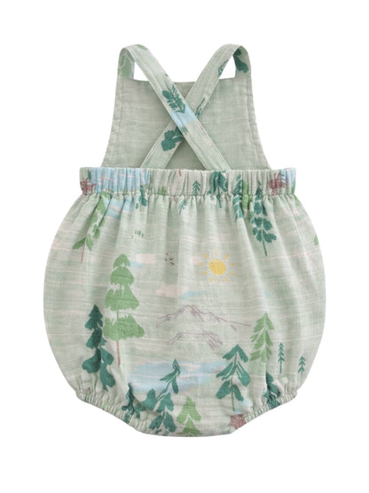 Green romper with crossback straps featuring mountain and tree patterns. Ideal for playful, outdoor adventures.