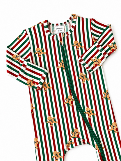 Red and green striped baby onesie with gingerbread cookie prints, featuring a zip closure and long sleeves.