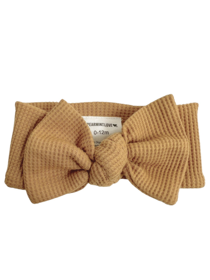 Tan baby headband with a knot, suitable for infants 0-12 months, by Spearmint Love.