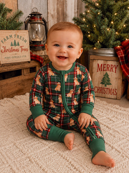 Smiling baby in festive pajamas with a dog pattern, sitting in a cozy holiday setting with Christmas decor.