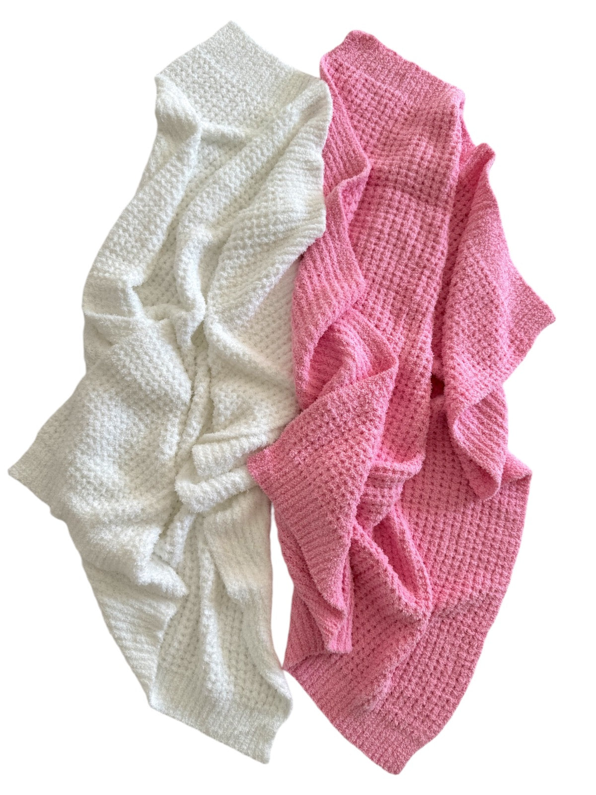 Two textured blankets, one white and one pink, overlapping on a white background.