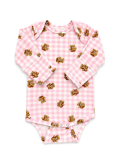 Pink gingham baby onesie with teddy bear print and long sleeves, featuring snap closures at the bottom.